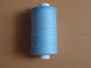 Il arrive qu'on ait besoin de bâtir un tissu en broderie d'embellissement, nous utilisons alors un fil très classique : du fil à bâtir